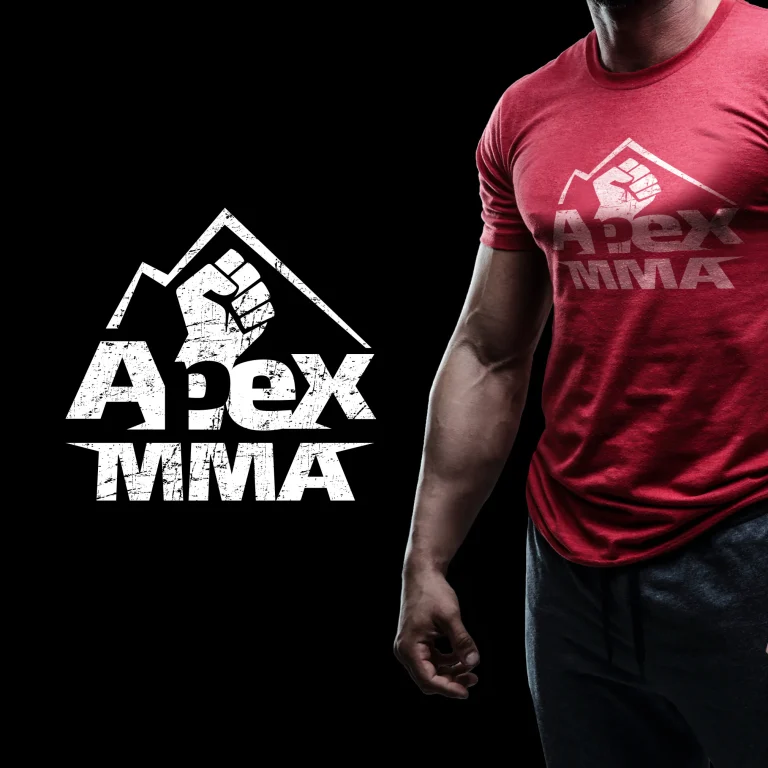 Дигитален макет на червена тениска с бяло лого Apex MMA, изобразяващо юмрук и планински връх с ефект на износване.