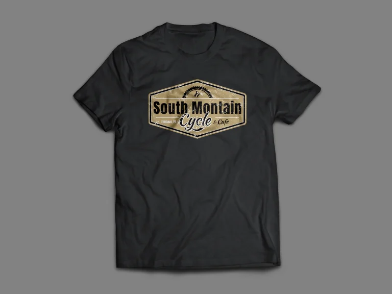 Дигитален макет на черна тениска с винтидж лого на South Mountain Cycle & Cafe, представено в шестоъгълна рамка.