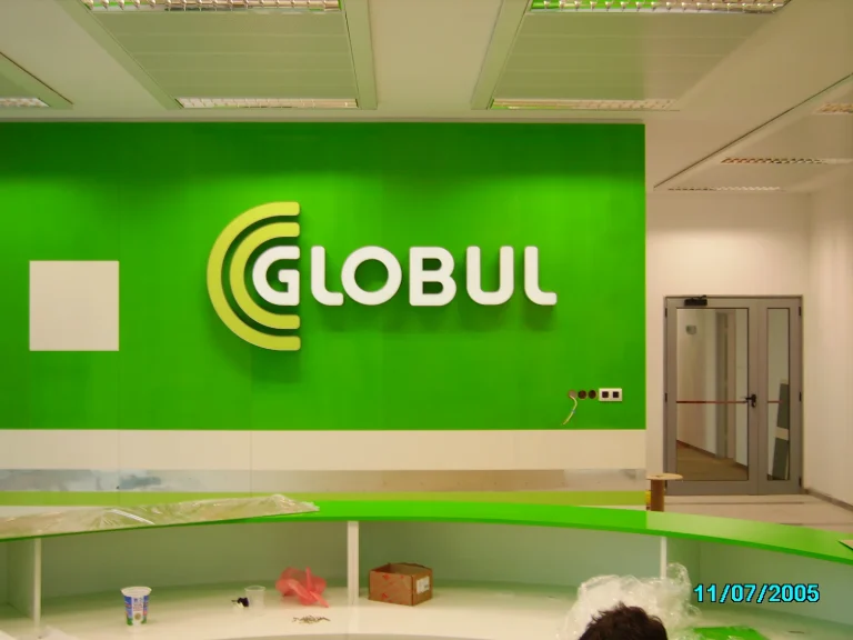 Обемни букви с логото на GLOBUL, монтирани върху яркозелена стена в интериор на офис пространство.
